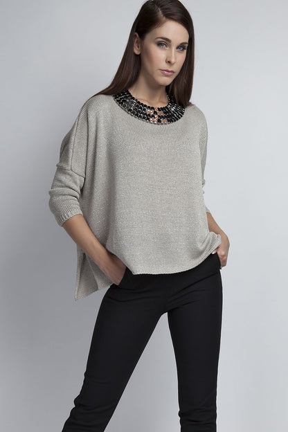 Woman wearing an oversized elegant sweater with silver threads, showcasing stylish comfy look for outings.