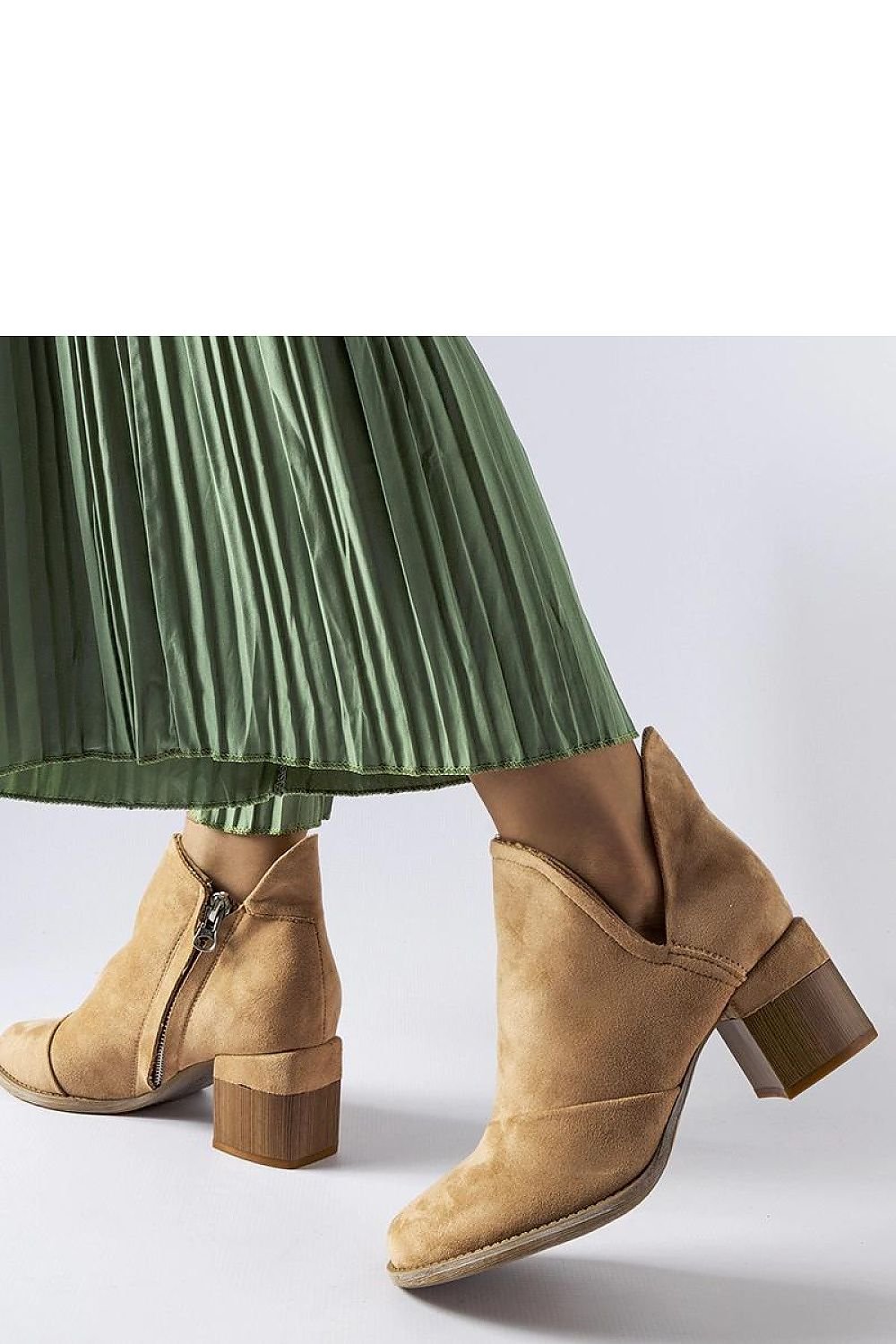 Woman wearing beige heeled ankle boots 204771 by Solea, paired with a green skirt, showcasing comfort and style.