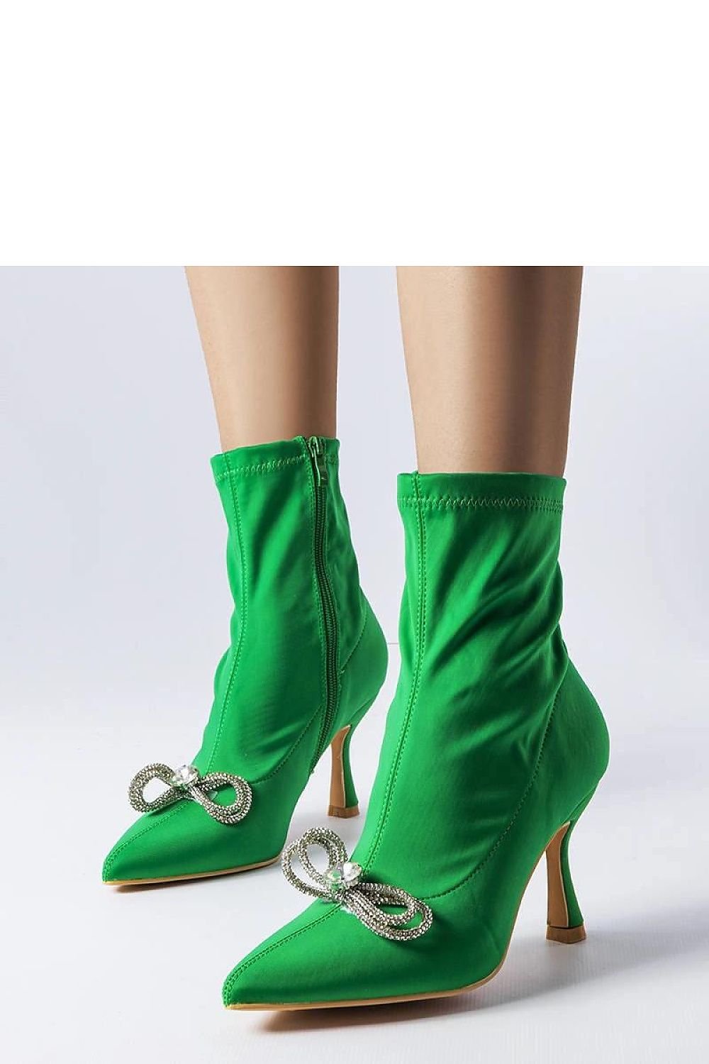 Green high heel ankle boots with rhinestone bow embellishments and side zipper, styled for fall/winter fashion.