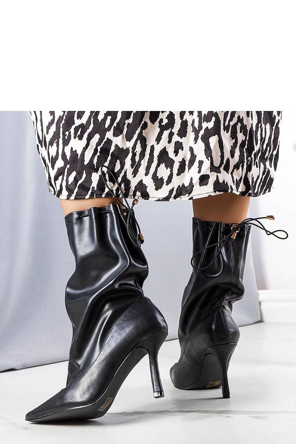 Elegant black high-heeled ankle boots with loose shaft, perfect for stylish fall fashion.