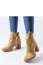 Women wearing Magassarkú bokacsízma model 206573 Solea beige ankle boots with frayed jeans, stylish fall fashion.