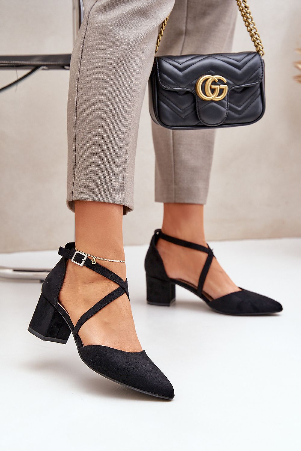 Black block heel shoes with crossover straps and designer handbag, perfect for elegant style and all-day comfort.