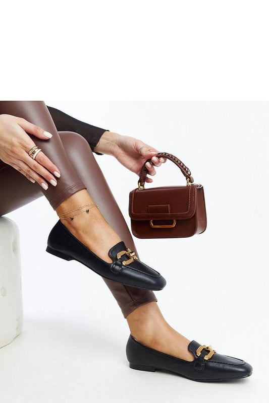 Fashionable black mokaszin with buckle detail, paired with brown handbag, showcasing elegant summer style.