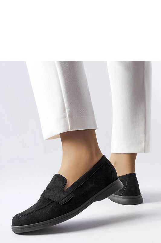 Stylish black moccasins in eco-friendly faux leather, perfect for elegance and comfort, as shown on model with white pants.