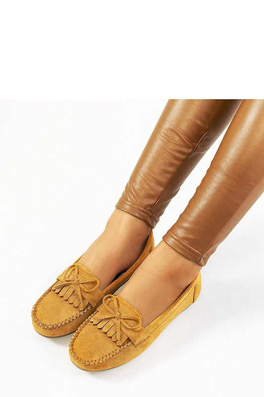 Elegant camel brown moccasins with tassel detail worn with leather leggings, perfect for a stylish spring look, featuring a comfy design.