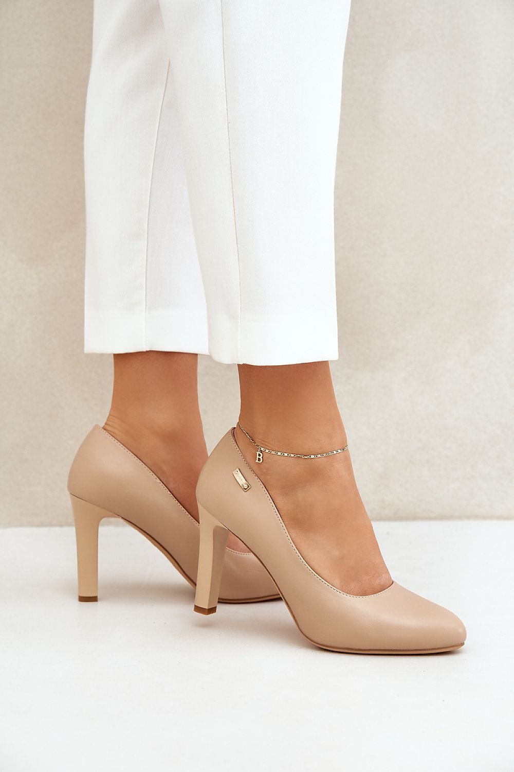 Classic beige high heels with almond toe and ankle bracelet, perfect for elegant occasions.