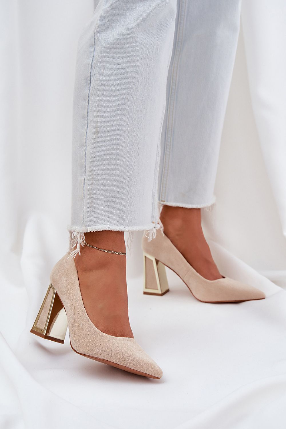 Beige high heels with metallic block heel paired with frayed hem jeans for a chic look.