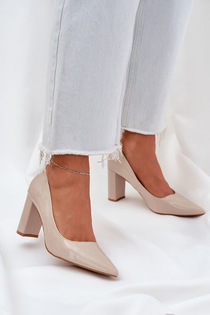 Elegant beige high heels with a pointed toe and block heel, paired with frayed hem jeans.