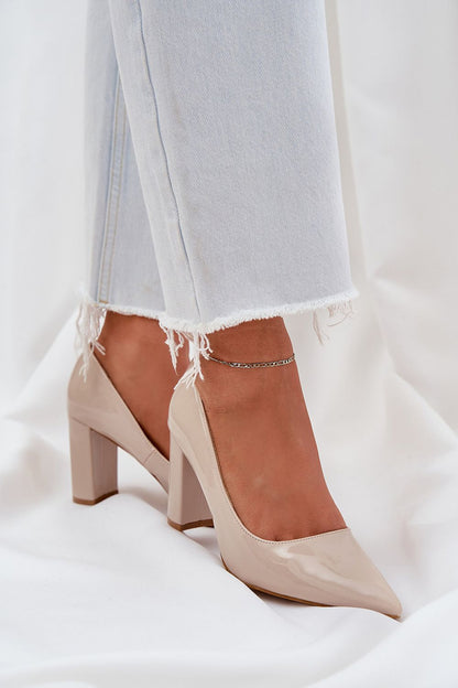 Elegant nude high-heeled shoes with pointed toes, styled with light-washed jeans for a chic look.