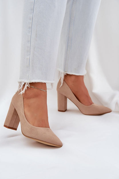 Beige high heel suede pumps paired with frayed hem jeans, showcasing elegance and style.