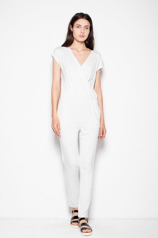 Model wearing white sporty jumpsuit with V-neck and drawstring waist by Venaton, showcasing short sleeves and tapered legs.