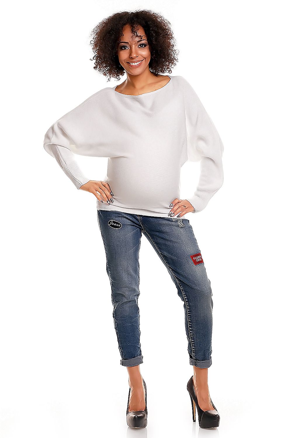 Pregnant woman wearing a white oversized maternity sweater with boat neckline and long sleeves, paired with jeans. Model 84269 PeeKaBoo.