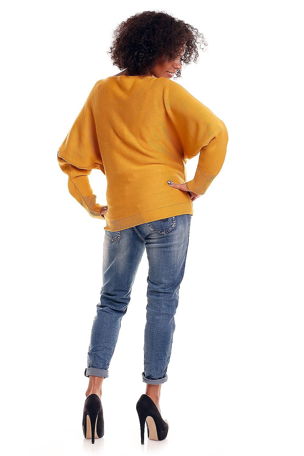 Back view of model wearing mustard oversized maternity pullover with kimono sleeves and scoop neck, paired with jeans and heels.