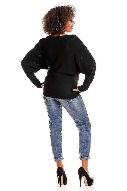 Back view of model wearing black oversized maternity sweater with kimono cut and wide boat neckline, paired with jeans and heels.