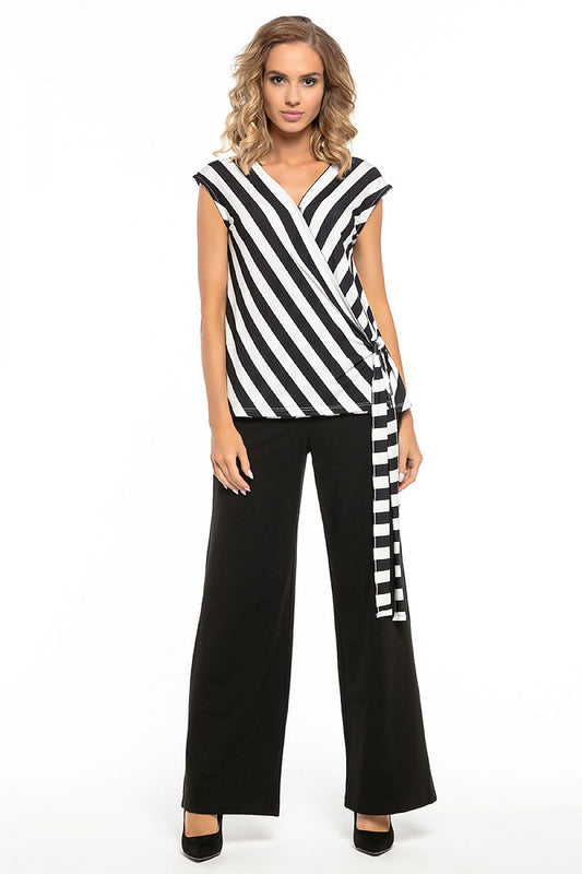 Woman wearing Tessita wide-leg black pants with striped top, ideal for various occasions. Black pants with pockets, made of cotton blend.