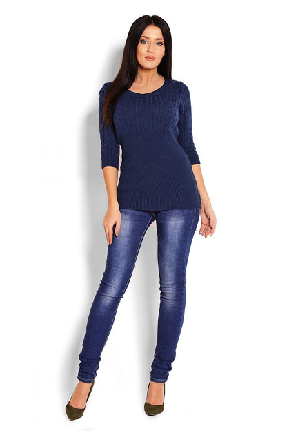 Model wearing a navy blue pulóver with cable knit design and 3/4 sleeves, paired with denim jeans. Stylish fall fashion.