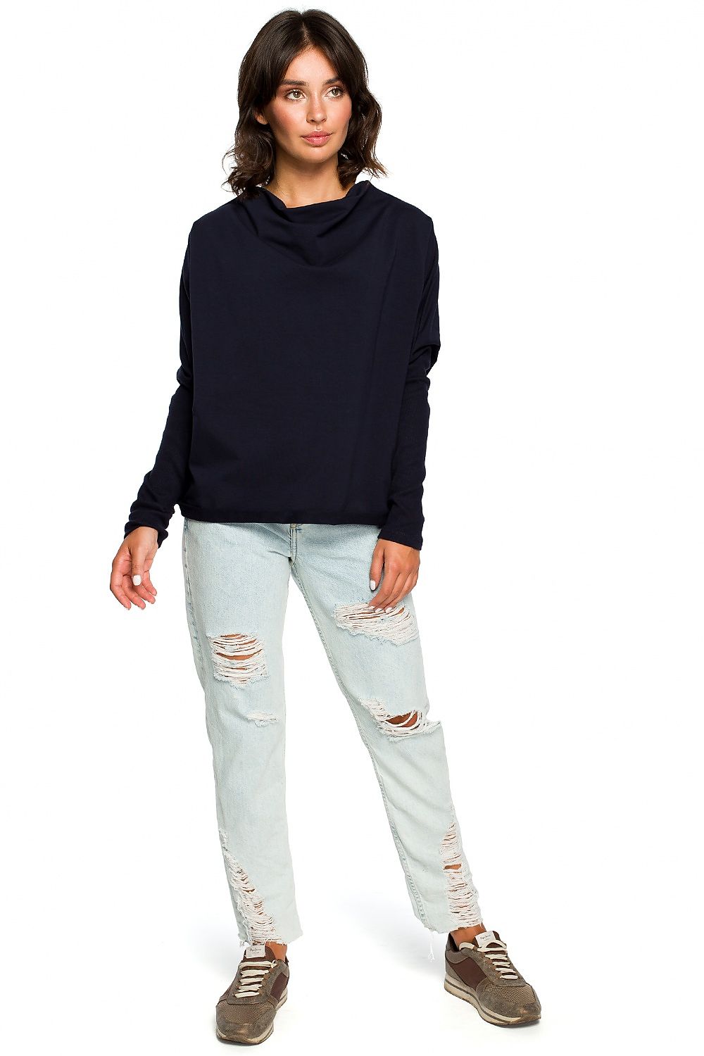 Woman wearing a casual black BeWear pullover with ribbed sleeves and draped neckline, paired with distressed jeans.