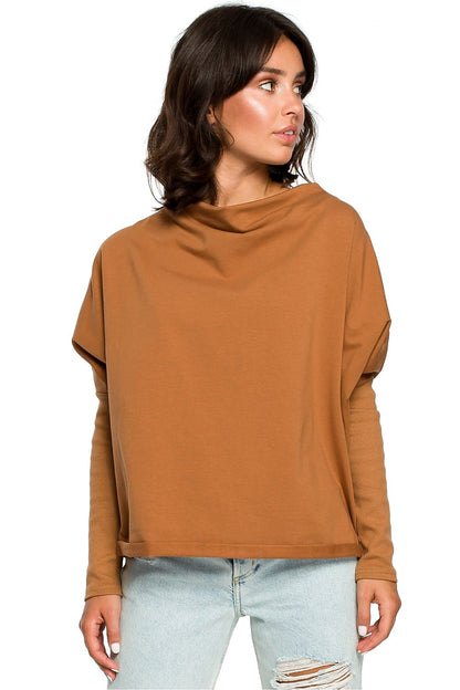 Woman wearing a casual brown top with ribbed sleeves and draped neckline, trendy and stylish look.