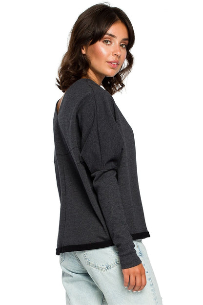 Woman wearing a Szabadidőfelső BeWear pullover with ribbed sleeves and draped neckline, styled with light jeans.