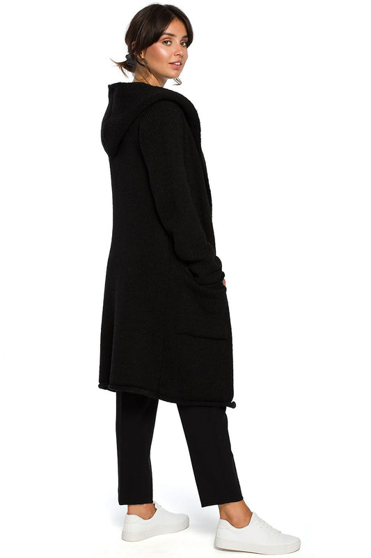 Woman wearing a long black hooded cardigan with pockets, styled for cooler weather