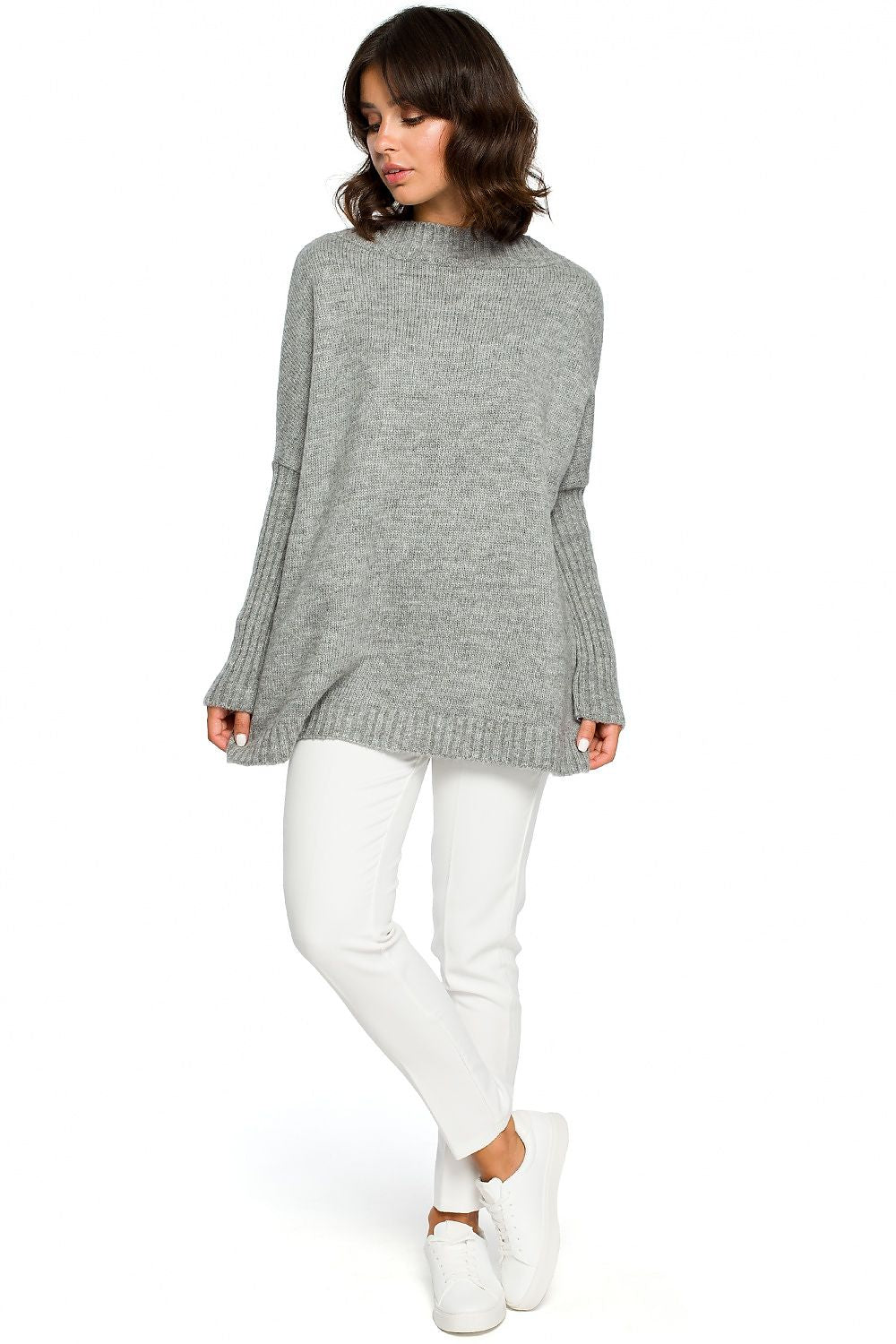 Model wearing gray knit pullover with kimono sleeves and white pants, showcasing a stylish casual look.