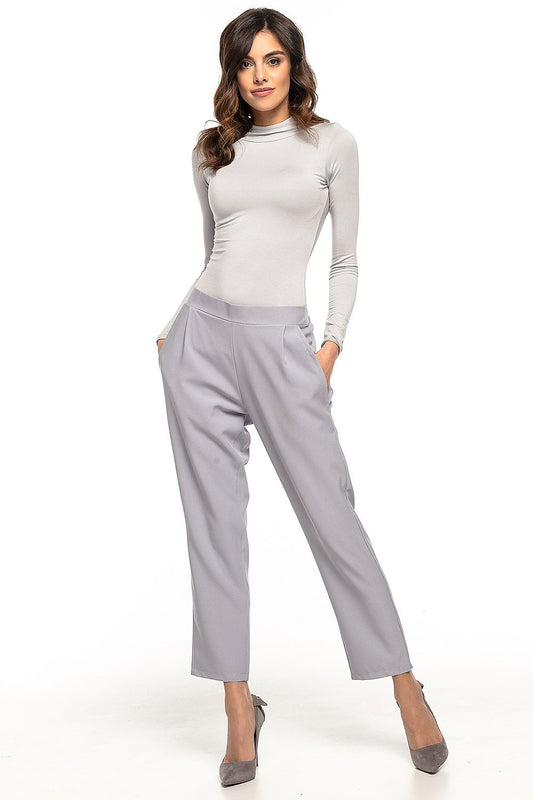 Woman wearing Tessita model 127885 cigarette-style pants with pockets, front pleats, slight taper, in a casual pose.