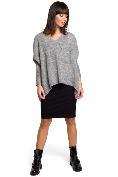 Model wearing Pulóver model 129166 BE Knit, a versatile grey sweater with loose neckline and ribbed sleeves, paired with a black skirt.