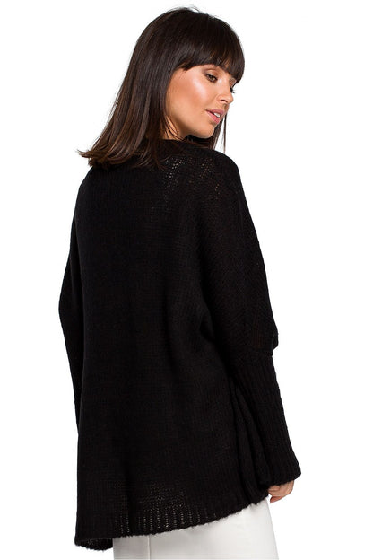 Stylish woman wearing a black Pulóver model 129166 BE Knit with loose neckline and ribbed sleeves, perfect for all seasons.