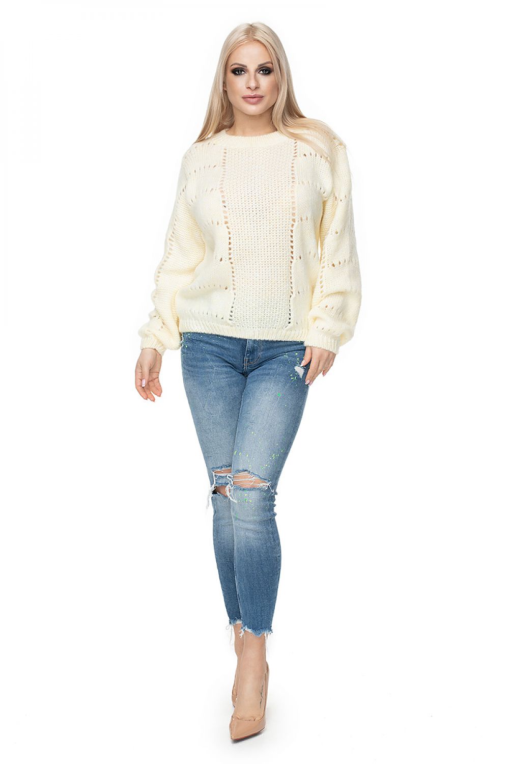 Model in white PeeKaBoo pulóver 131600, soft wool blend with openwork pattern, paired with ripped jeans and heels.