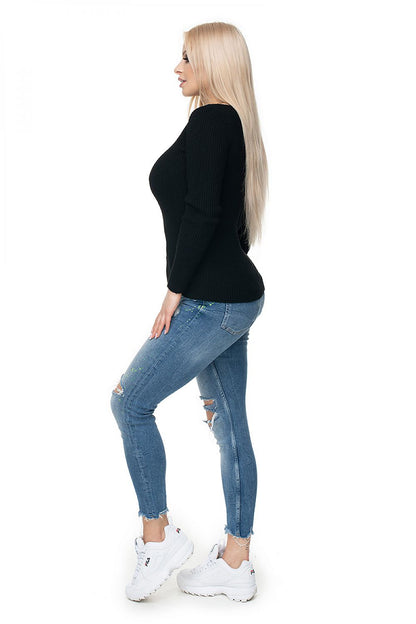 Model wearing black ribbed Pulóver 131606 by PeeKaBoo with boat neckline, paired with distressed jeans and white sneakers.