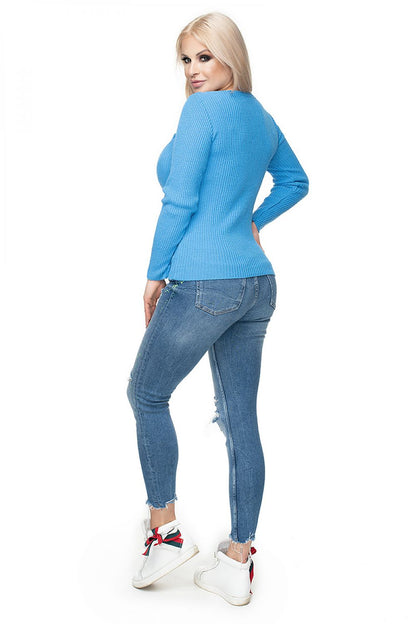 Woman wearing blue ribbed peekaboo pullover model 131606, with boat neckline and classic fit, paired with jeans and white sneakers.