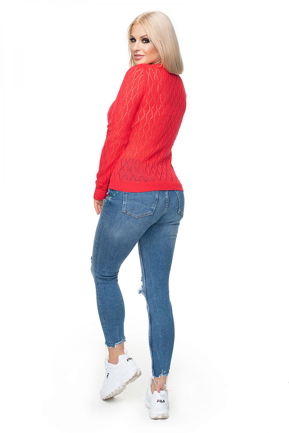 Woman wearing a red PeeKaBoo pulóver model 131609 with diamond motif and jeans, showcasing stylish and comfortable fashion.