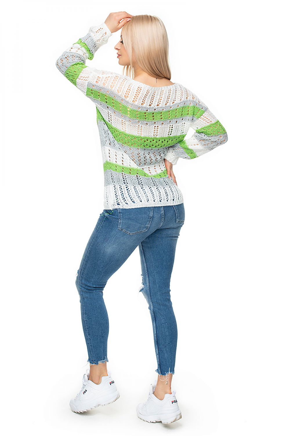 Woman wearing model 131612 PeeKaBoo short striped pullover in colorful, open-knit design with jeans and white sneakers.