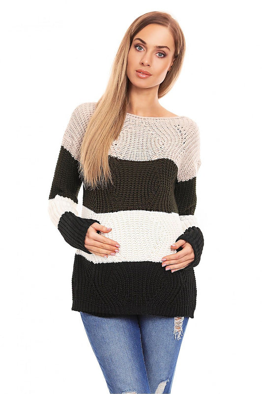 Model wearing a striped maternity pullover with long sleeves and intriguing patterns, featuring black, white, and beige colors.