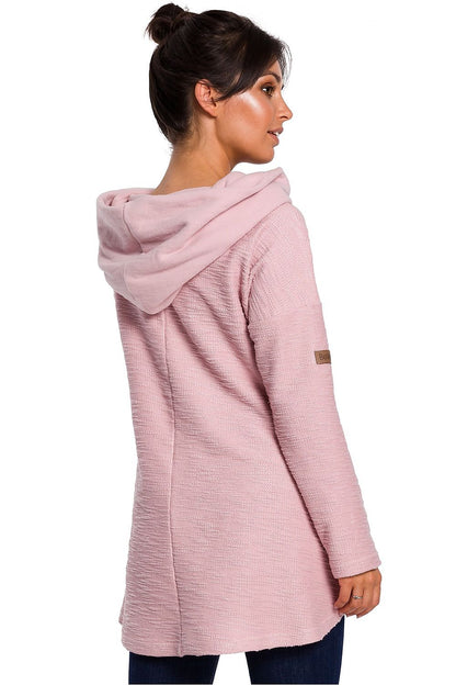 Back view of woman wearing pink asymmetrical hoodie with pockets, showcasing cozy fashion for cold seasons.