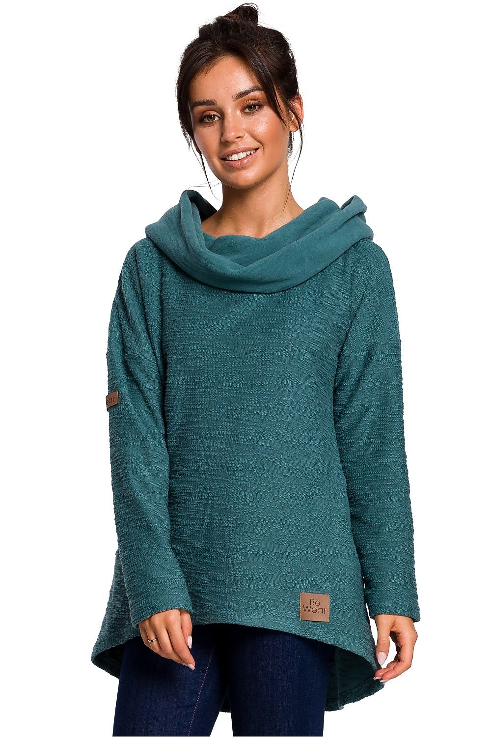 Woman wearing teal asymmetric pullover with cowl neck and hood, perfect for colder seasons. BeWear Model 134537.