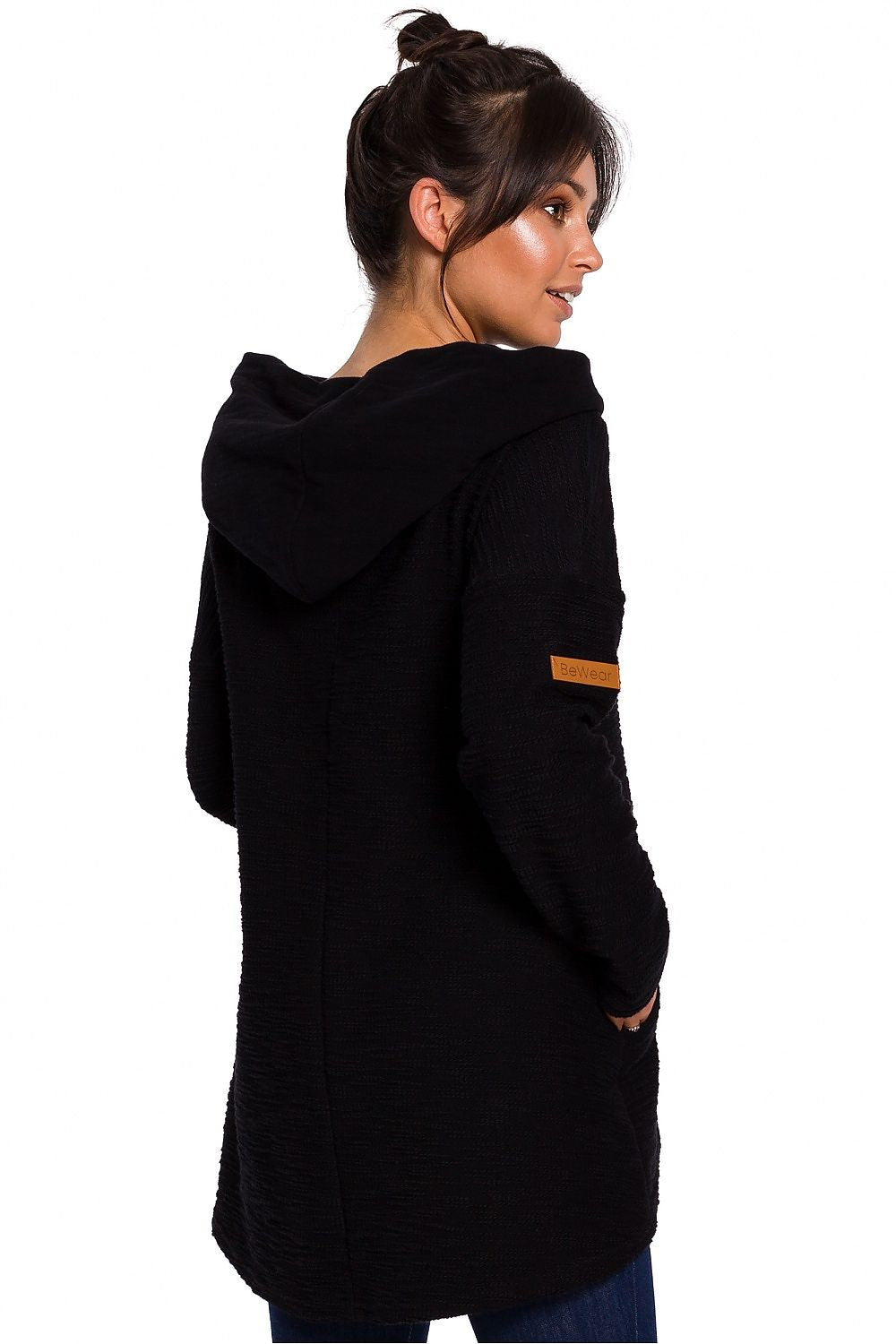 Model wearing BeWear Szabadidőfelső 134537, black asymmetric pullover with hood and pockets, perfect for cold weather.