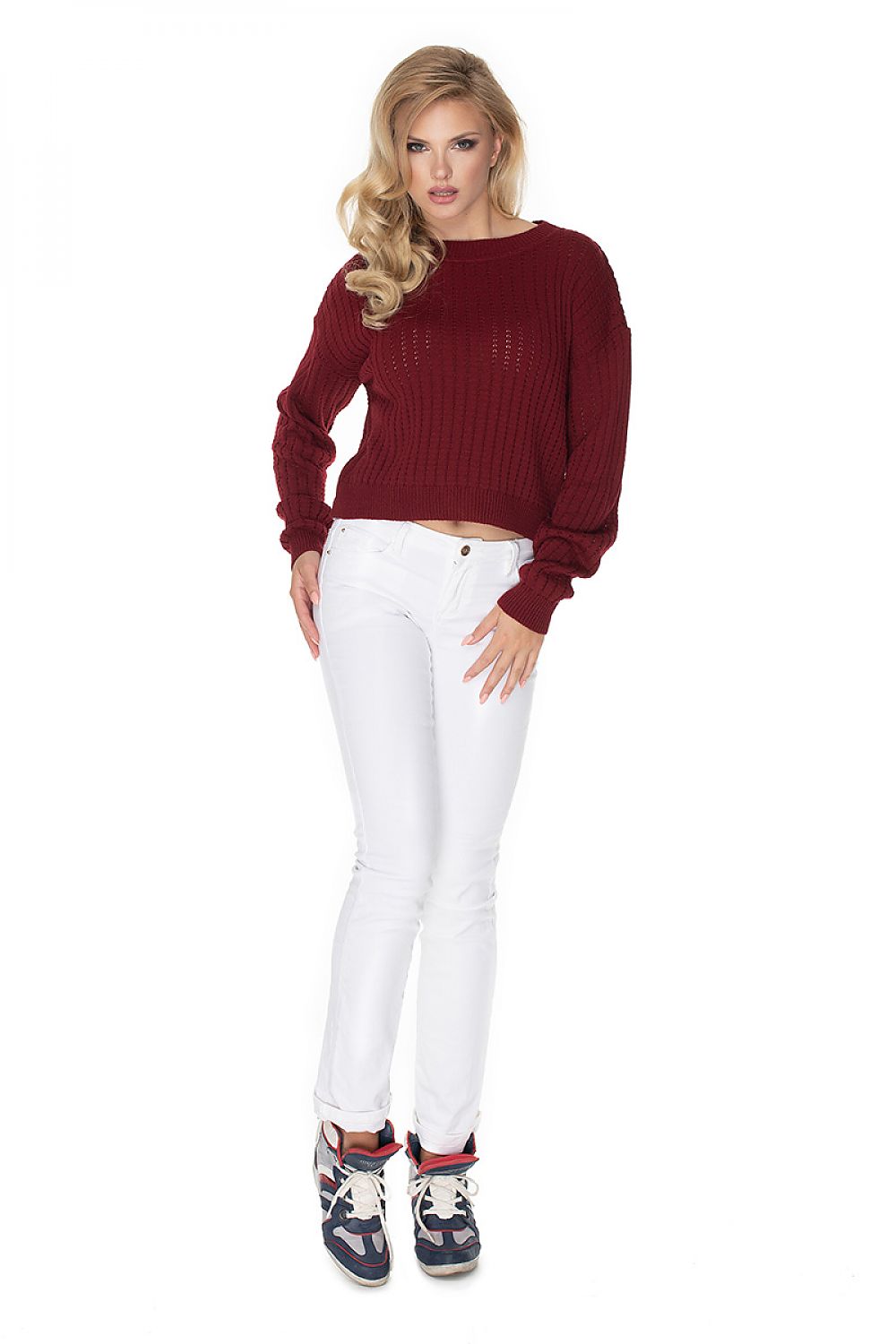 Model wearing red Pulóver 134598 PeeKaBoo with boat neck and unique stitching, paired with white jeans and sneakers.