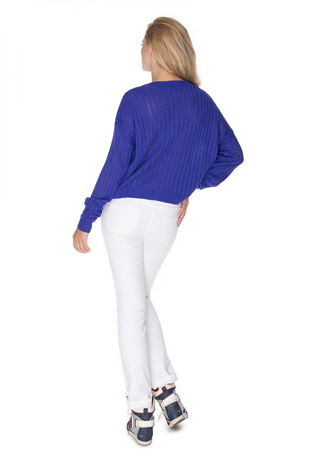 Model wearing blue PeeKaBoo pulóver model 134598 with unique stitching, boat neckline, and long sleeves, paired with white jeans.