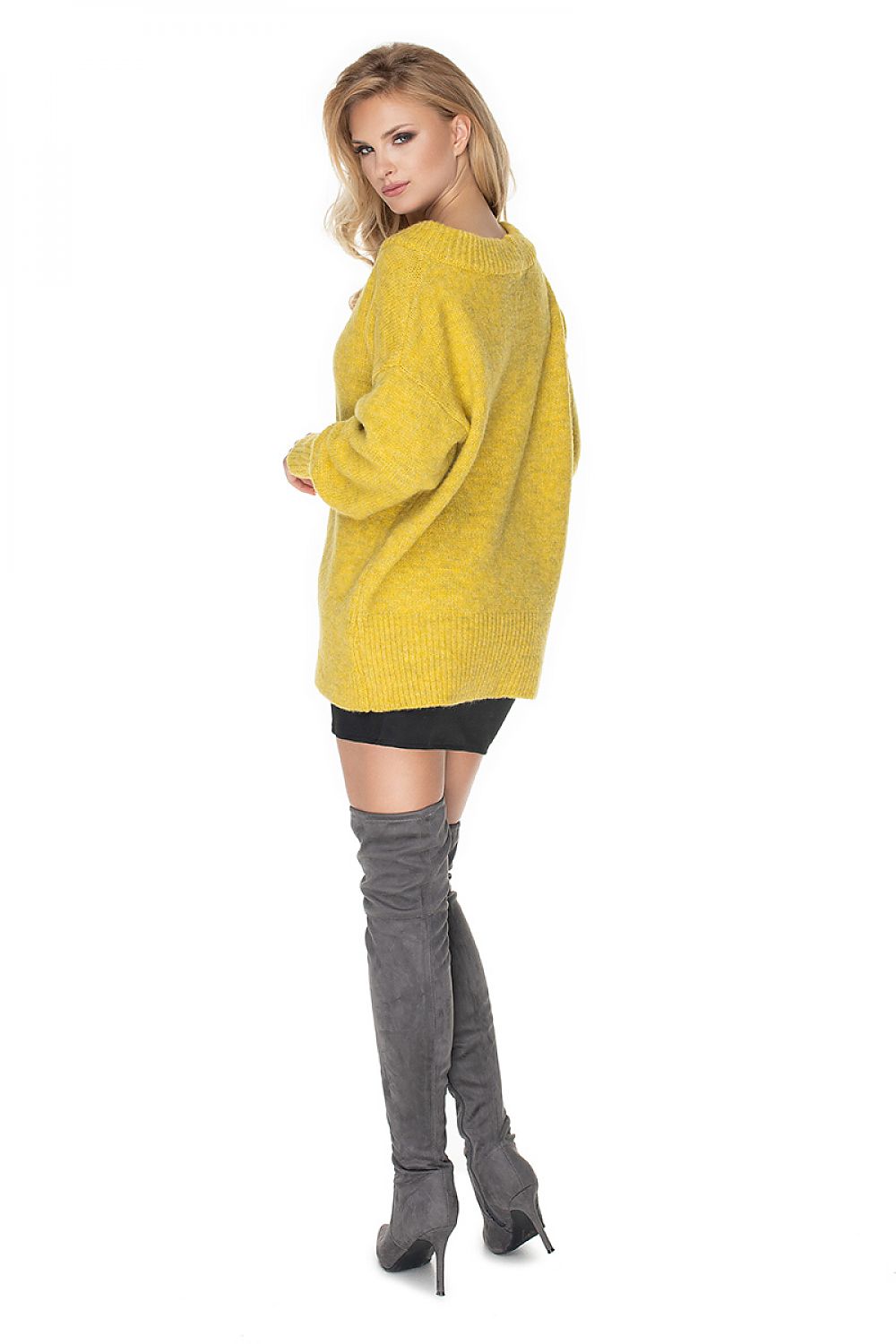 Woman wearing Pulóver model 135317 PeeKaBoo, yellow oversized wool blend sweater with boat neckline and long sleeves, styled with high boots.