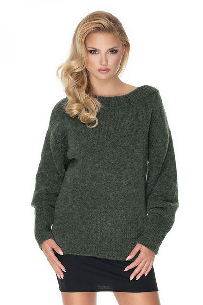 Woman wearing a green PeeKaBoo pullover, loose fit with wool, boat neckline, and long sleeves. Model 135317, cozy and stylish fashion.