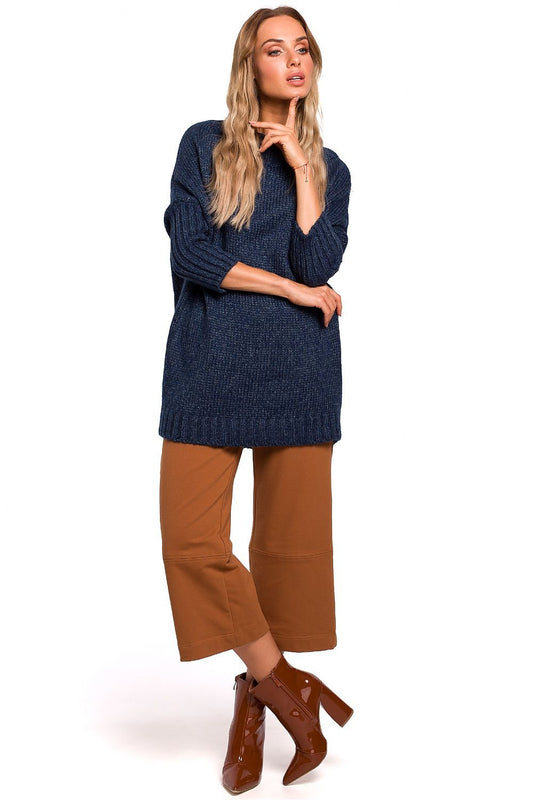 Model wearing Pulóver model 135432 Moe, navy oversized sweater with ribbed hem and long sleeves, paired with brown pants and boots.