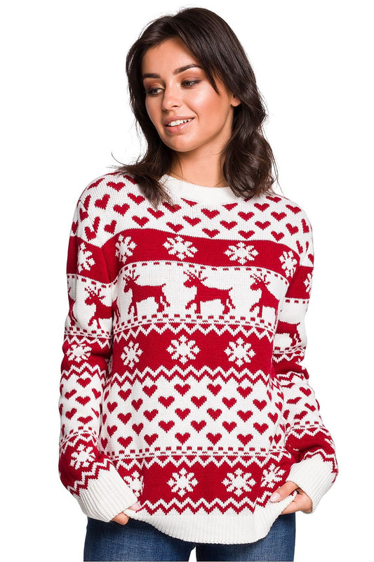 Woman wearing red and white Christmas sweater with reindeer patterns, perfect for cozy winter evenings by the fireplace.