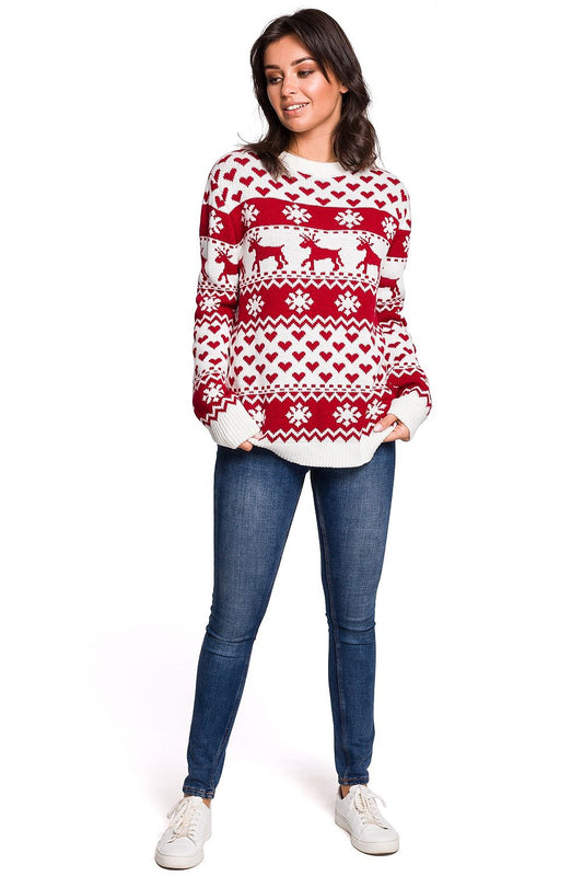 Woman wearing red and white reindeer Christmas sweater, standing in blue jeans and white sneakers, perfect for cozy winter nights.