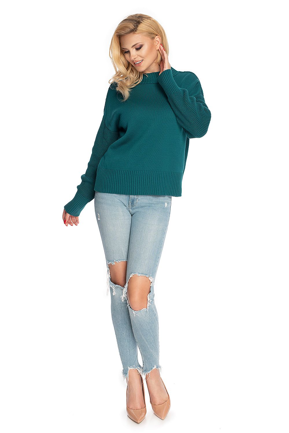 Woman wearing teal PeeKaBoo pulóver model 146913 with long sleeves and ribbed hem, paired with ripped jeans and heels.