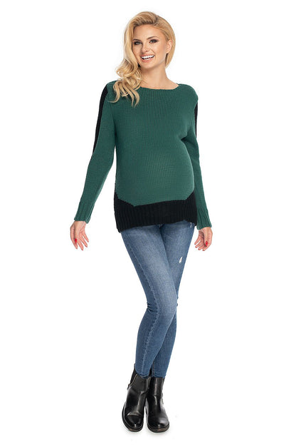 Model wearing green PeeKaBoo maternity sweater, csónaknyakú style, decorative side panels, paired with jeans and boots.