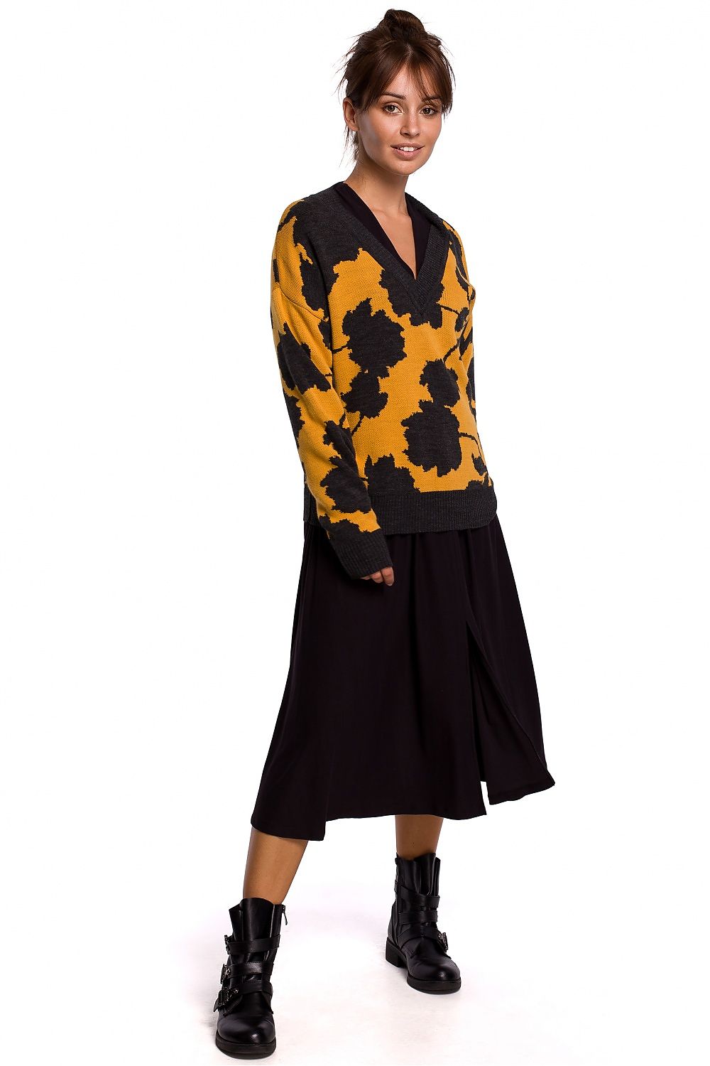 Elegant pullover model 148237 BE Knit with V-neck and floral pattern in yellow and black, worn by a woman with a black skirt and boots.