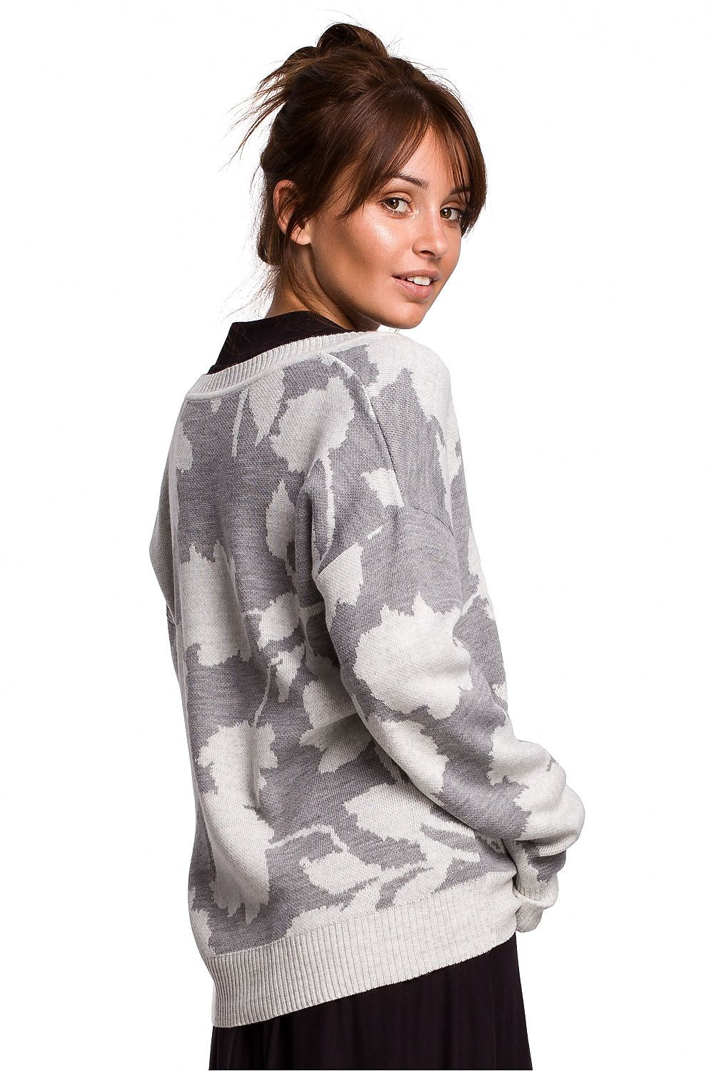 Model wearing elegant gray knit pullover with unique floral pattern and V-neck, showcasing style and comfort.