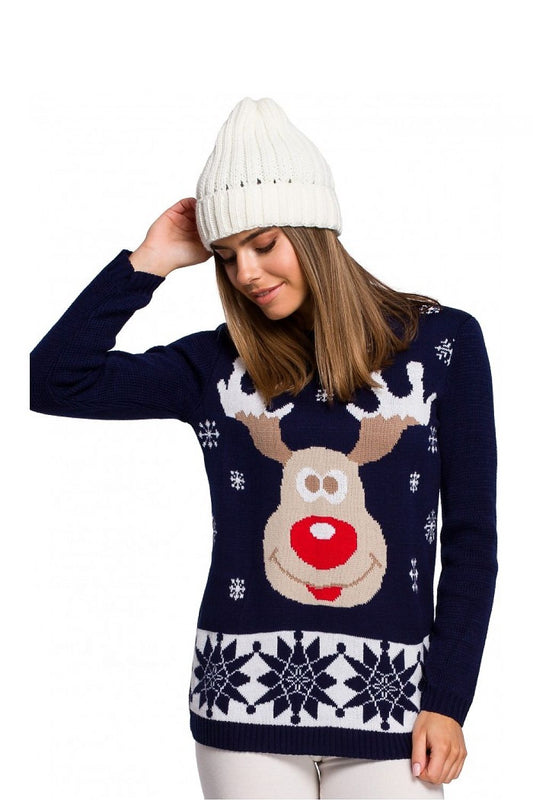 Woman wearing a festive Christmas sweater with reindeer motif and a white knit hat, showcasing pulóver model 150212 Moe.