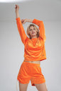 Orange velour pullover with ribbed cuffs by Figl, Szabadidőfelső model 154668, showcasing comfy style and vibrant color.